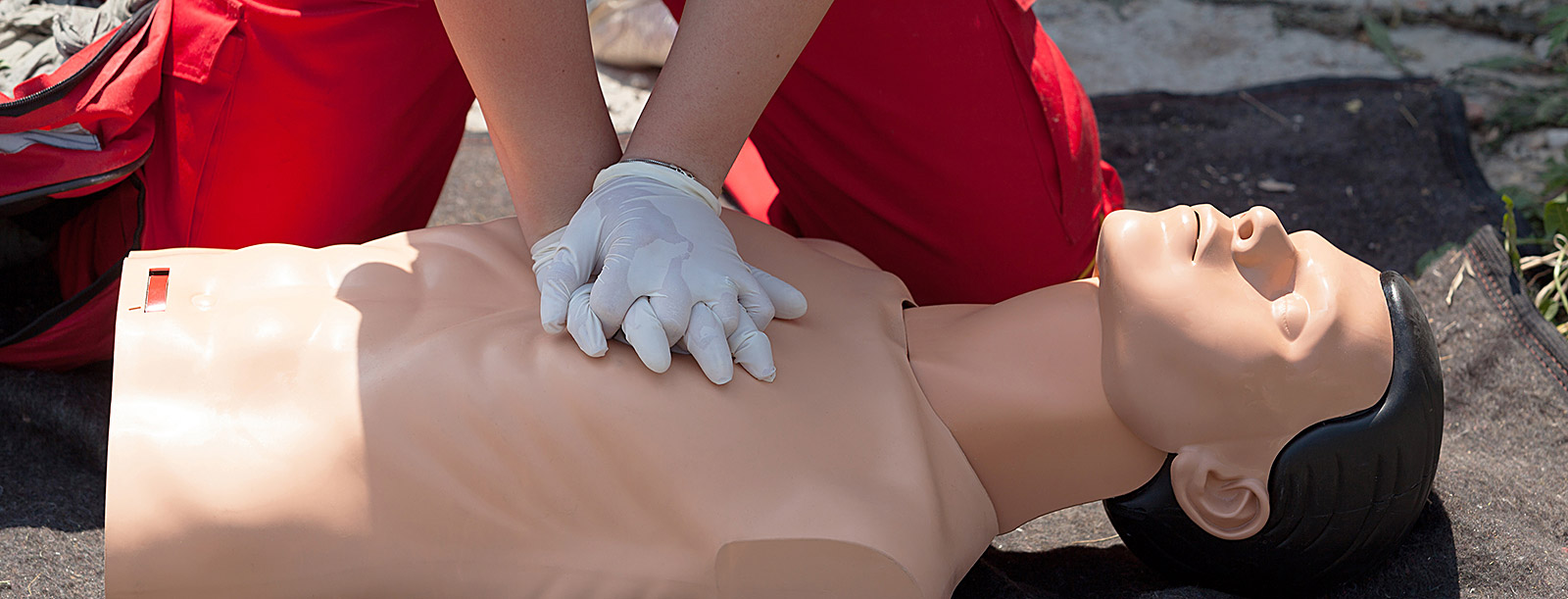 hands performing chest compressions on dummy