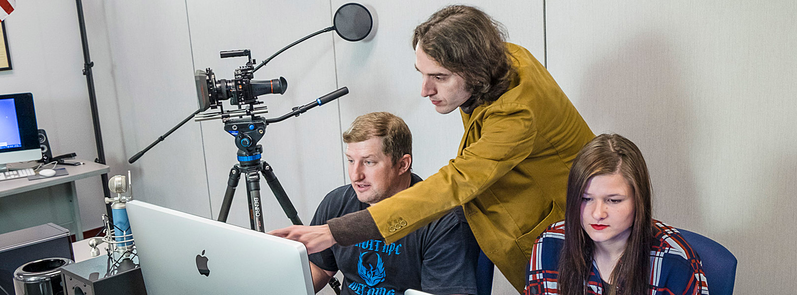 instructor helping student edit film on computer