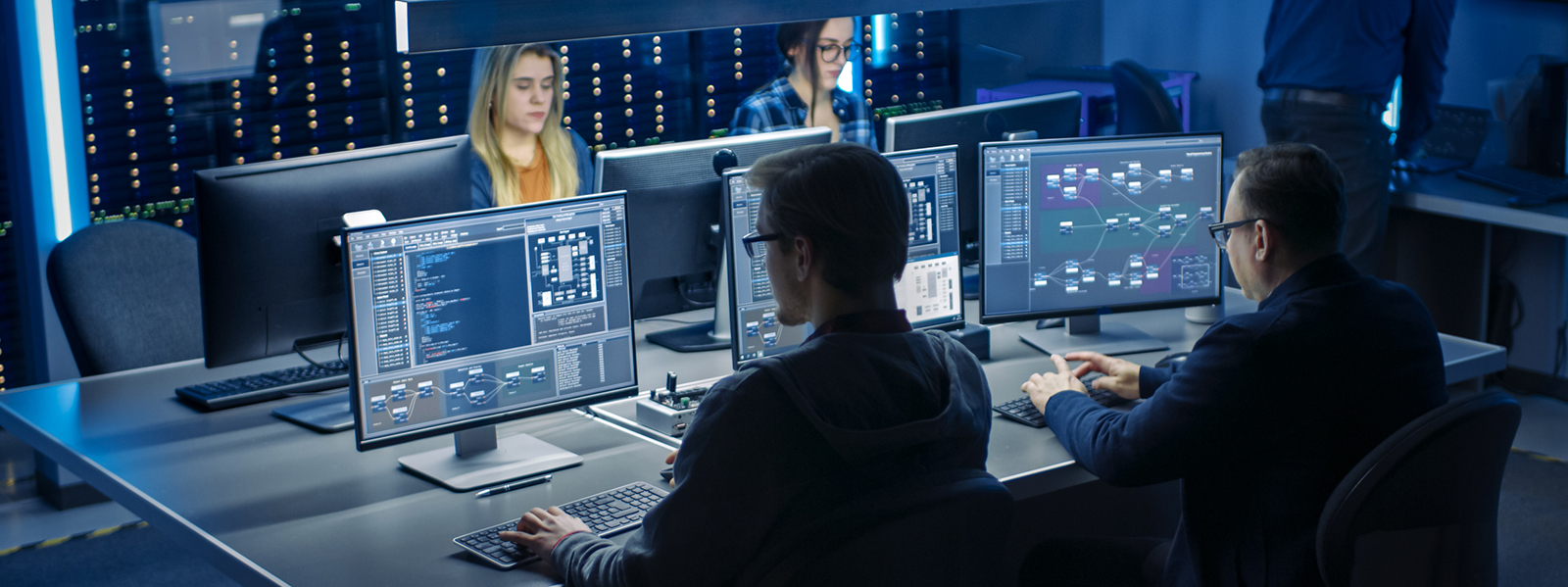 several people in a room working on computer programming