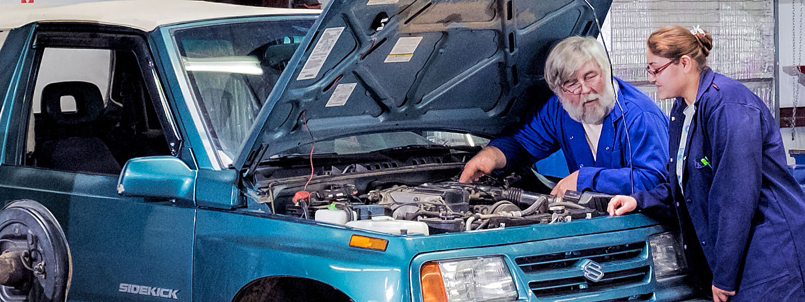 instructor shows femal student engine