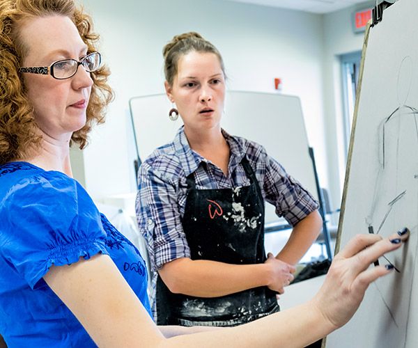 instructor helping female student draw