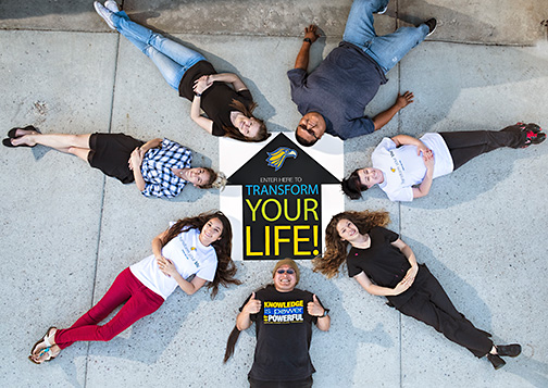 students laying on the ground around the transform your life logo